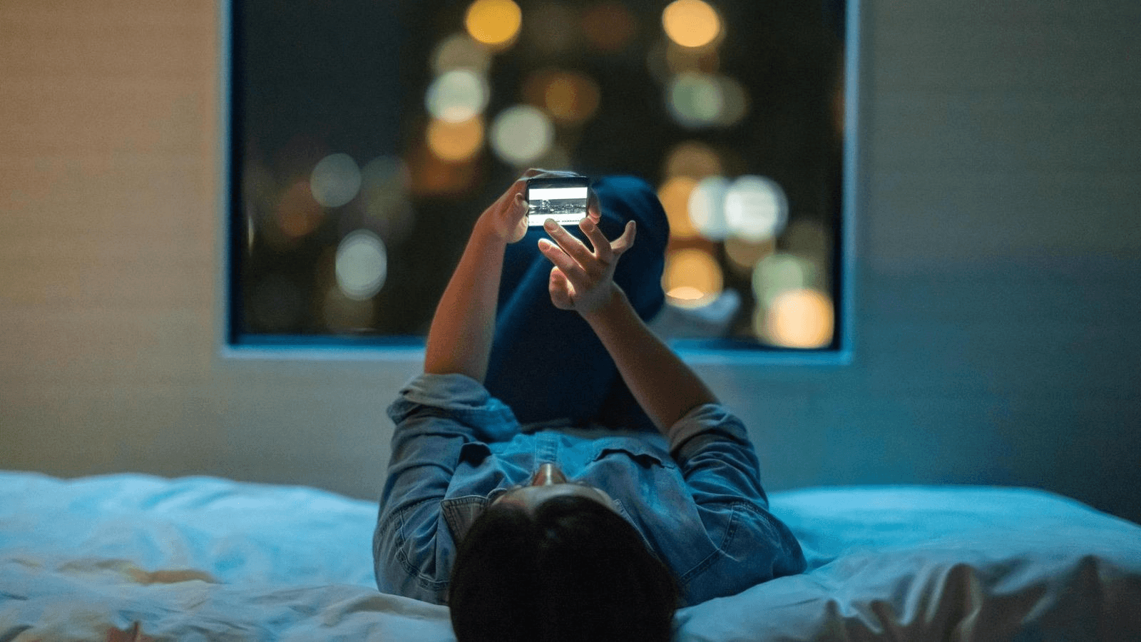 Person alone at night scrolling through their phone